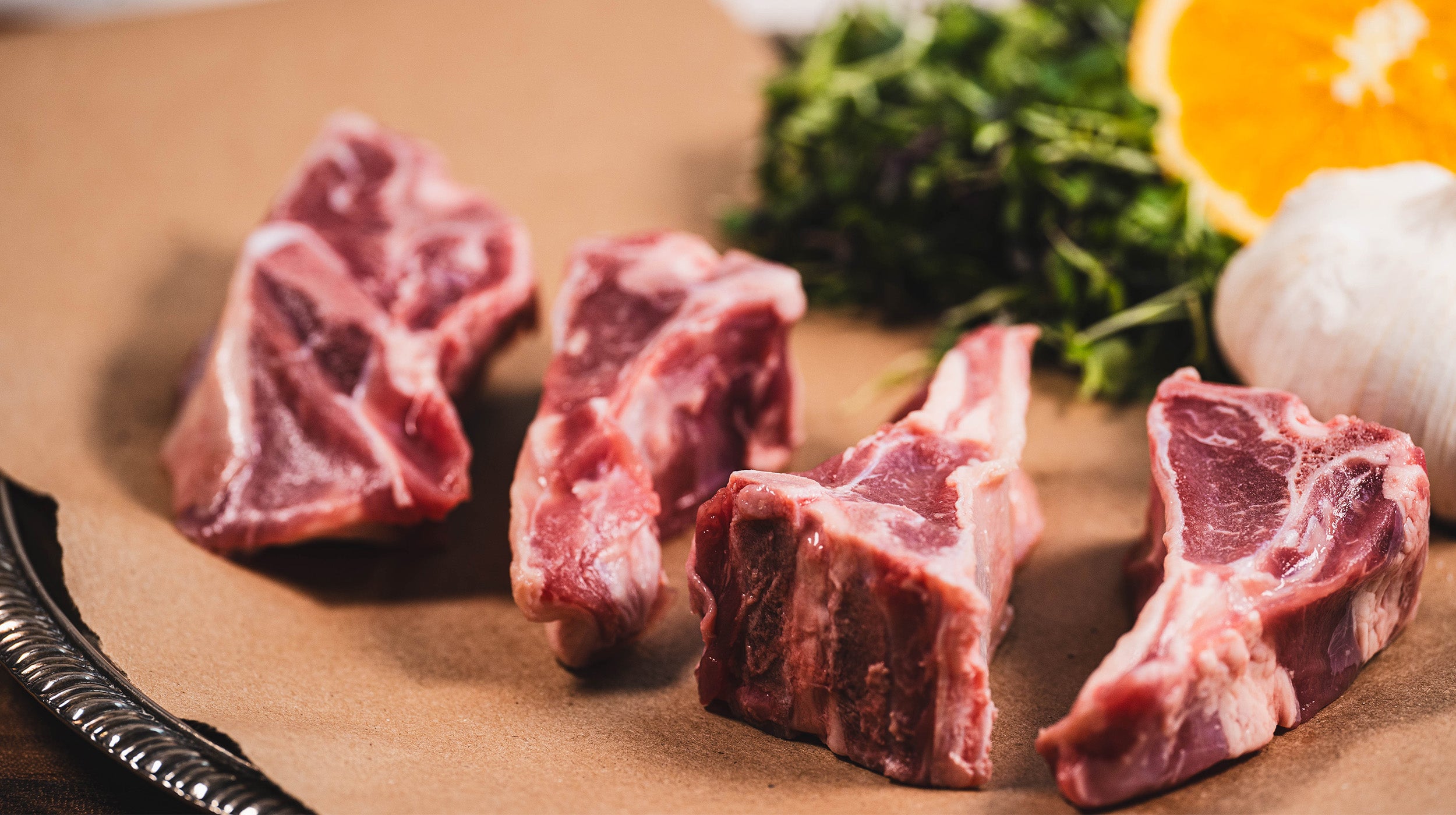 Pasture raised goat chops, plated raw, on butcher paper. Sawyer Bloodline Spanish Goats
