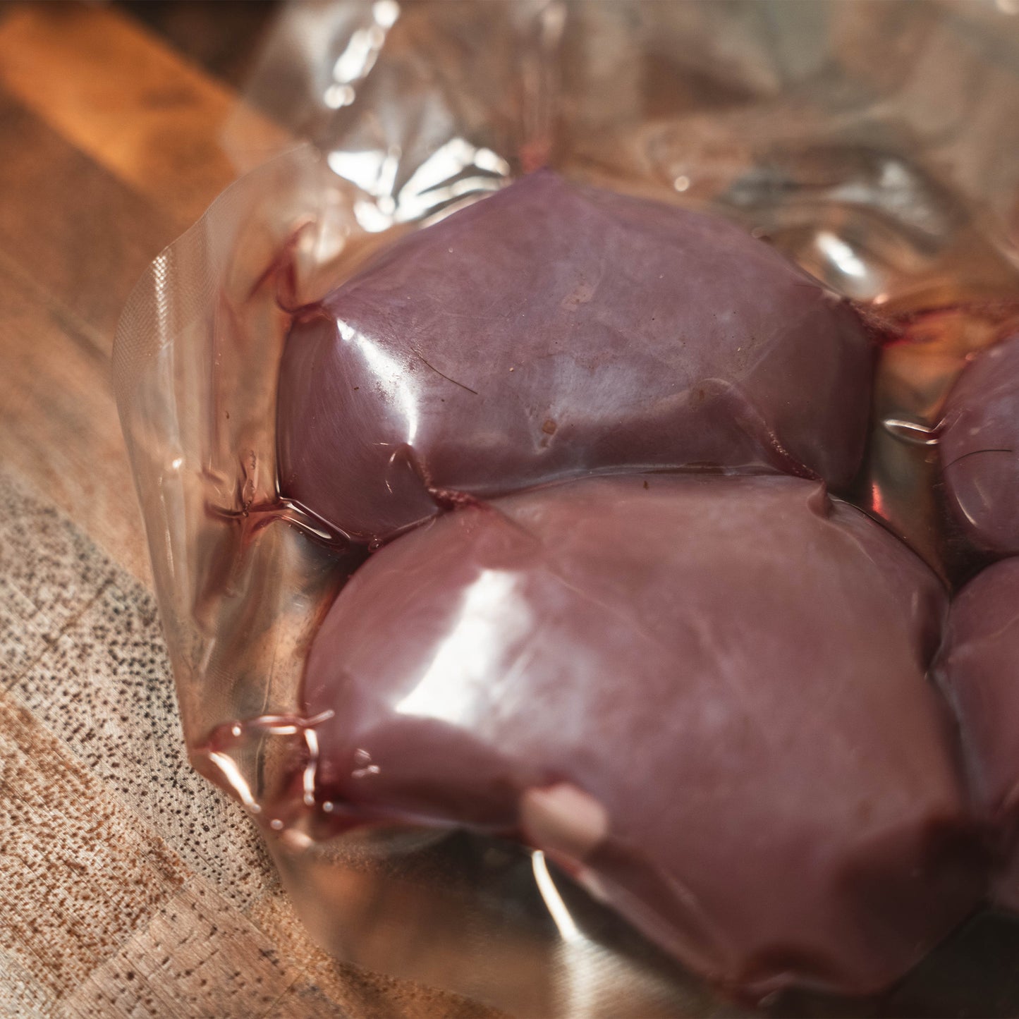 Pasture-raised raw goat kidneys sealed for freshness in clear vacuum packaging.
