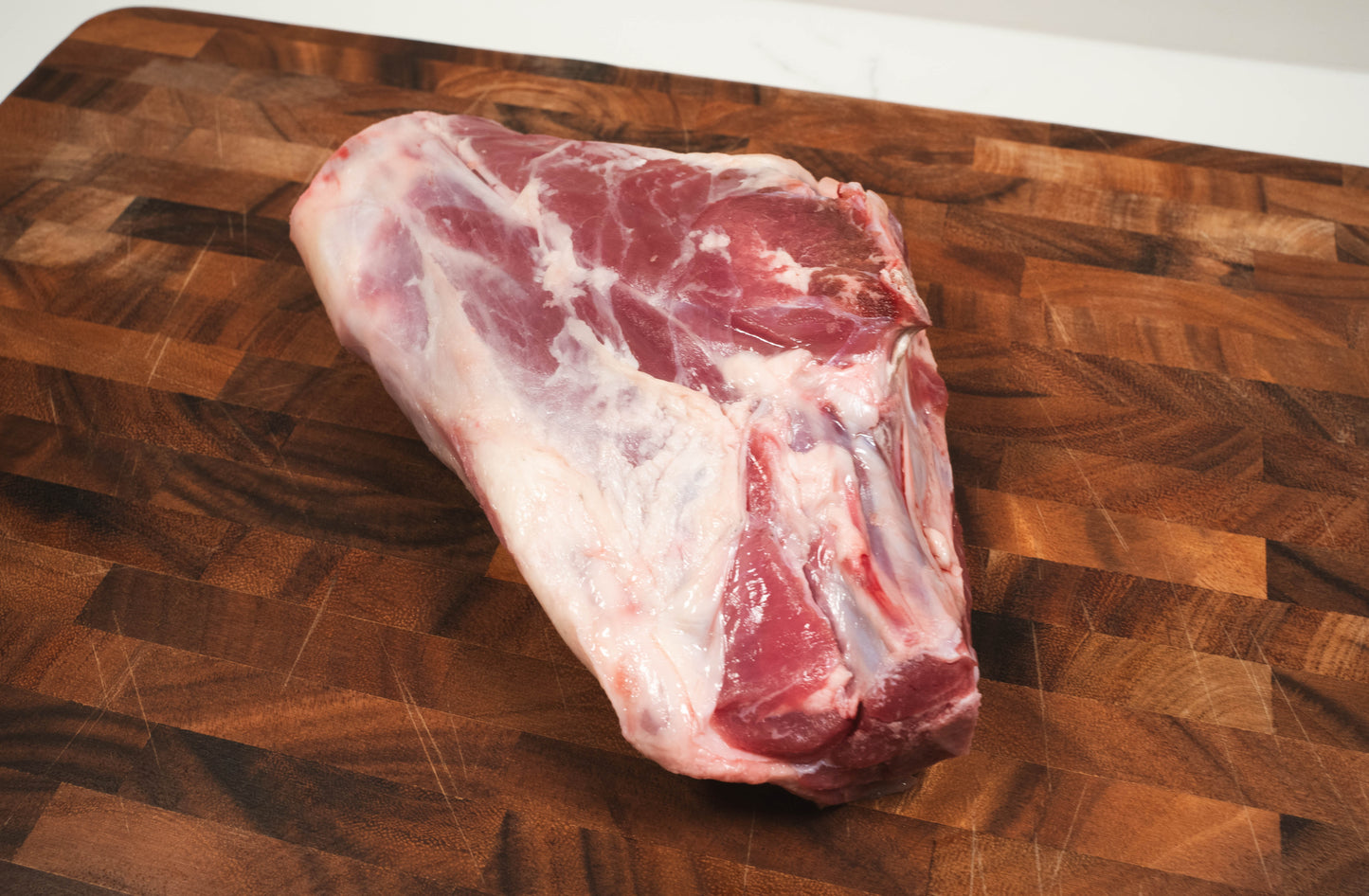 Sustainably Raised Goat Meat, Goat Leg butcher cut on wooden cutting board